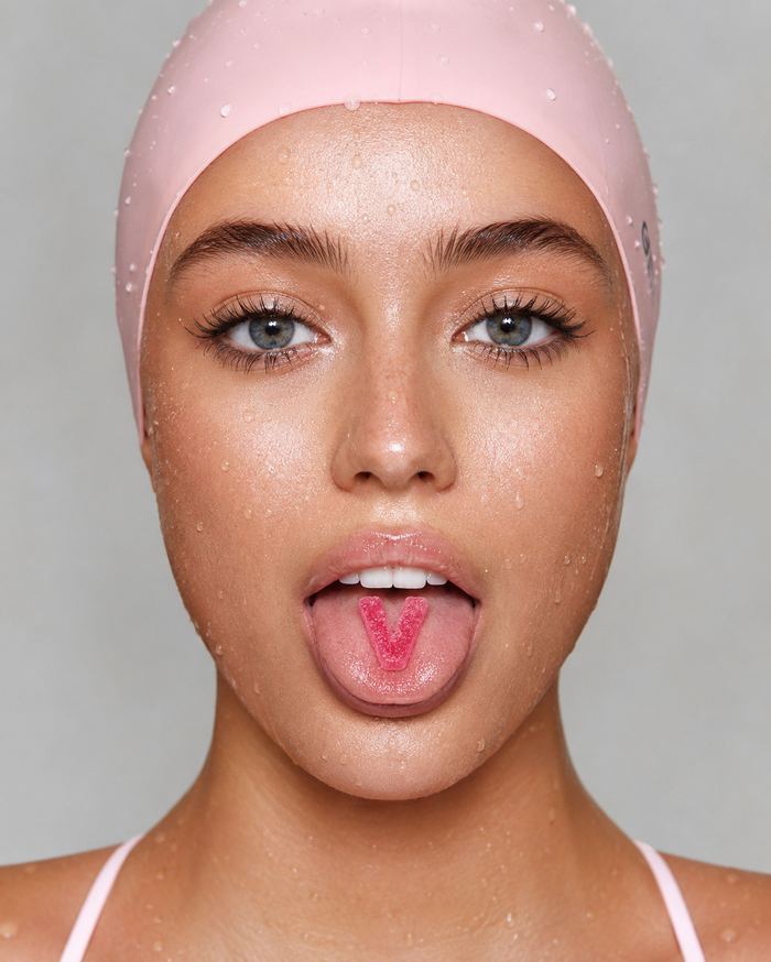 Beauty close-up with wet skin and a pink swim cap