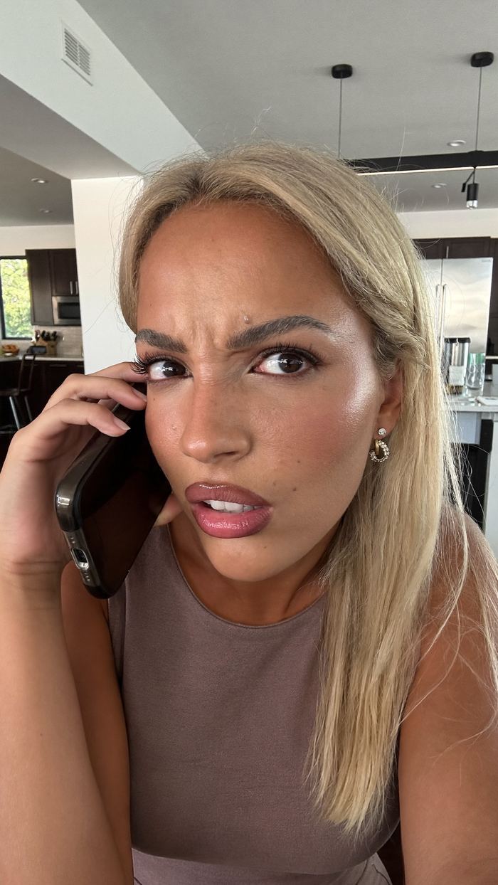 UGC style selfie of a woman reacting on a phone call