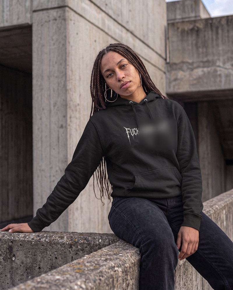 Model wearing a black graphic hoodie on concrete steps