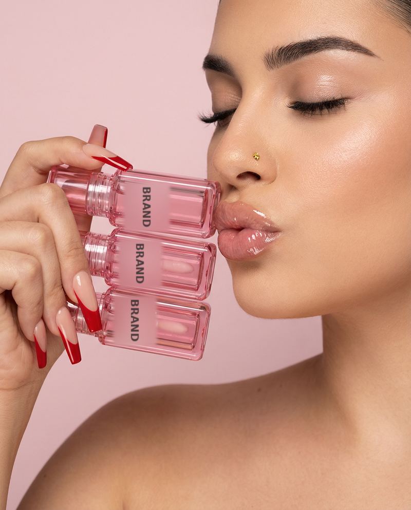 Model kissing a stack of lip oil bottles